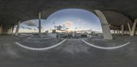 a panorama camera looking out over an empty parking lot at sunset outside of a city