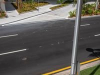 a street view looking down on a paved intersection with a yellow line coming out of the corner