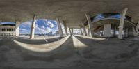 a mirror is reflecting the sun and clouds in a skate park area above a city