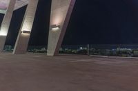 a long row of cement pillars with lights around them on the top of a concrete building