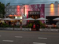 an empty street with tables and umbrellas outside of a restaurant that is set up for diners