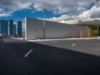 the view from across the street with the modern buildings in the distance, and the empty lot