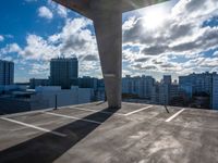 a parking garage with a sky and clouds in the background taken from inside a building