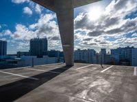 a parking garage with a sky and clouds in the background taken from inside a building