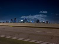 city lights streaking in the background while overpasses pass on the highway into a freeway