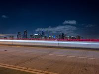 city lights streaking in the background while overpasses pass on the highway into a freeway