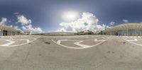 an airport parking lot with a bus and airplane taxi stop under a partly cloudy blue sky