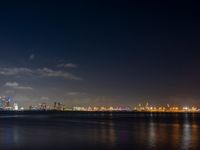 night scene with a view of the city lights and river from across the bay, and city skyline in distance