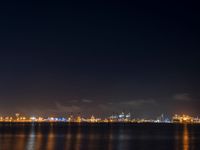 night scene with a view of the city lights and river from across the bay, and city skyline in distance