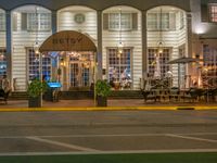 the entrance to the restaurant is lit up by candles and umbrellas on the sidewalk