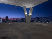 the rooftop parking deck has great view of a city below it and blue sky above