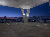 the rooftop parking deck has great view of a city below it and blue sky above