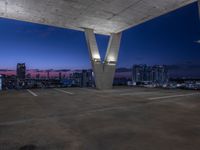 the rooftop parking deck has great view of a city below it and blue sky above