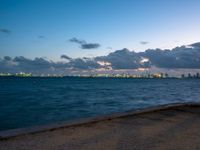 the ocean and city in the distance at twilight seen from the waterfront in miami, florida