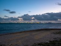 the ocean and city in the distance at twilight seen from the waterfront in miami, florida