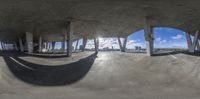 this image shows a wide panorama of the interior of an abandoned building with multiple circular windows