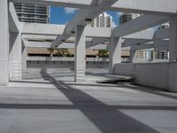 a parking garage with an area for bikes and skateboards to parked with buildings in the background