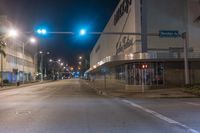 an empty street at night lit by green traffic lights for pedestrians and businesses in the city