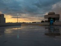 there is water on the ground with a cloudy sky behind it and lights on the side