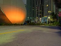 there is an image of a giant sphere on the side of the street with a lot of tall buildings behind it