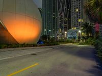 there is an image of a giant sphere on the side of the street with a lot of tall buildings behind it