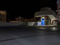 an outdoor parking lot with a fire hydrant and a blue light in the dark