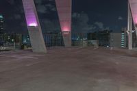 this image shows the view of a parking garage and city lights in the distance, in a darkened environment