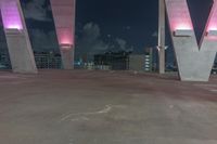 this image shows the view of a parking garage and city lights in the distance, in a darkened environment
