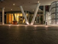 a courtyard outside a building, with a fire hydrant next to it at night