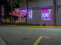 an outside photo of a restaurant at night with neon signs on the side of the building