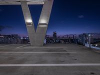 a tall white letter v sits on top of a roof above a city at night