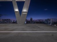 a tall white letter v sits on top of a roof above a city at night