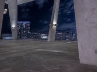 a man standing on top of a cement ramp at night with buildings and clouds behind him