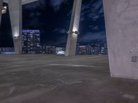 a man standing on top of a cement ramp at night with buildings and clouds behind him