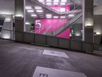 a stairway going up to several different platforms in a building with a bright pink wall