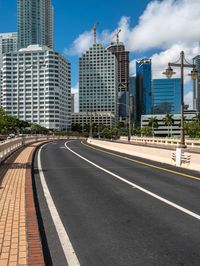 a paved street runs between two tall buildings in a downtown area with high rise towers