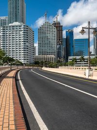 a paved street runs between two tall buildings in a downtown area with high rise towers