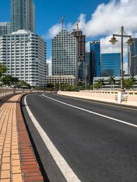 a paved street runs between two tall buildings in a downtown area with high rise towers