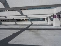 a parking garage with multiple benches and street signs next to buildings along the sidewalk and skylights