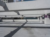 a parking garage with multiple benches and street signs next to buildings along the sidewalk and skylights