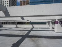 a parking garage with multiple benches and street signs next to buildings along the sidewalk and skylights