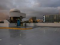 a parking lot in an airport at dusk on a cloudy day with a blue door