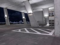 a parking garage with a sky view over cityscape and traffic signs at night