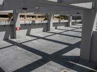 a parking garage with a car park space underneath a building in the middle of the day