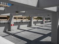 a parking garage with a car park space underneath a building in the middle of the day