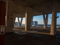 a parking lot with no one in it and a view of the city through columns