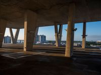 a parking lot with no one in it and a view of the city through columns