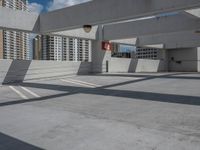 an empty parking lot with no one standing next to the curb and buildings in the background