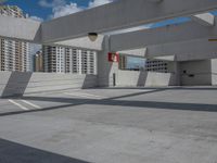 an empty parking lot with no one standing next to the curb and buildings in the background