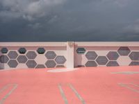 a black and white photo of a white building and a red and gray wall with different patterns